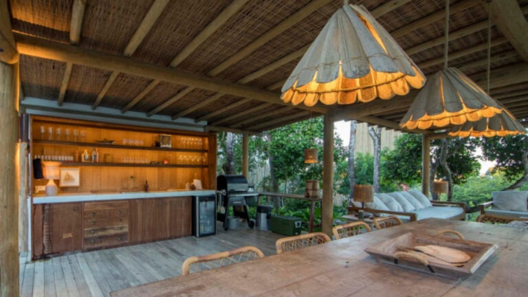 Localizada na colina do Alto do Segredo, propriedade da Origem Trancoso oferece ampla vista para o mar e conforto dividido entre a casa principal e um bangalô independente, somando quatro suítes com ar-condicionado e camas King size. Diária na alta temporada fica em R$ 8 mil, enquanto pacote de Réveillon sai por R$ 350 mil