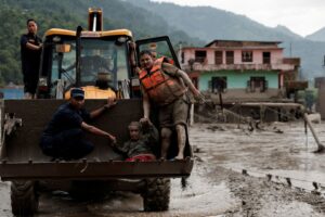 Sobrevivente é transportado em escavadeira após enchente repentina em Trishuli, no distrito de Nuwakot, no Nepal