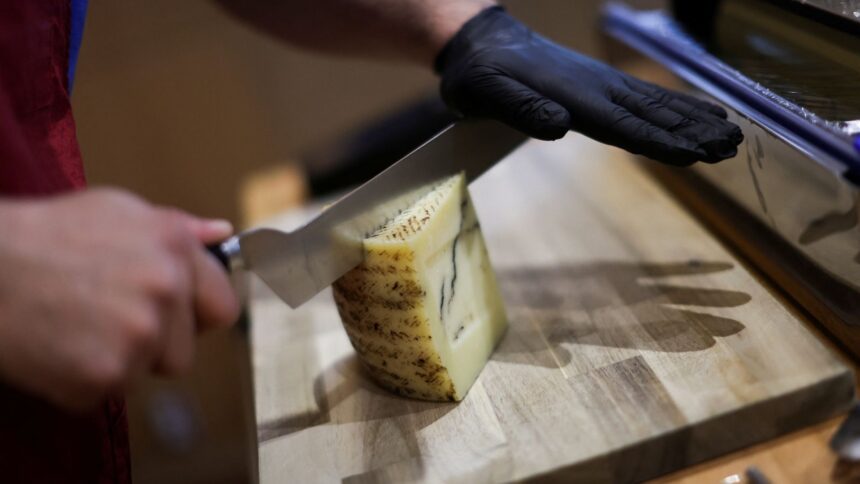 Funcionário corta queijo curado com trufas importado da Espanha em uma loja na Cidade do México