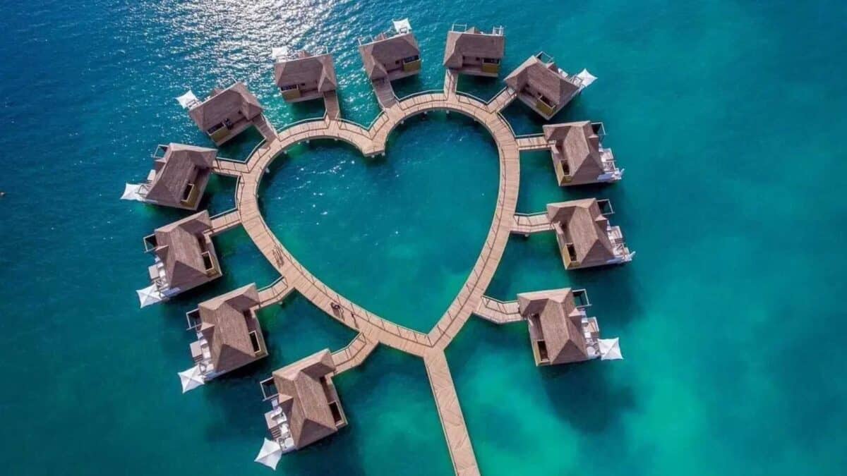 Vista aérea de resort de luxo no Caribe com piscinas privativas e mar azul