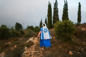 Colono judeu caminha em direção a oliveiras de propriedade de palestinos, que estão prestes a ser colhidas, perto do assentamento israelense de Neve Daniel, na Cisjordânia ocupada por Israel
